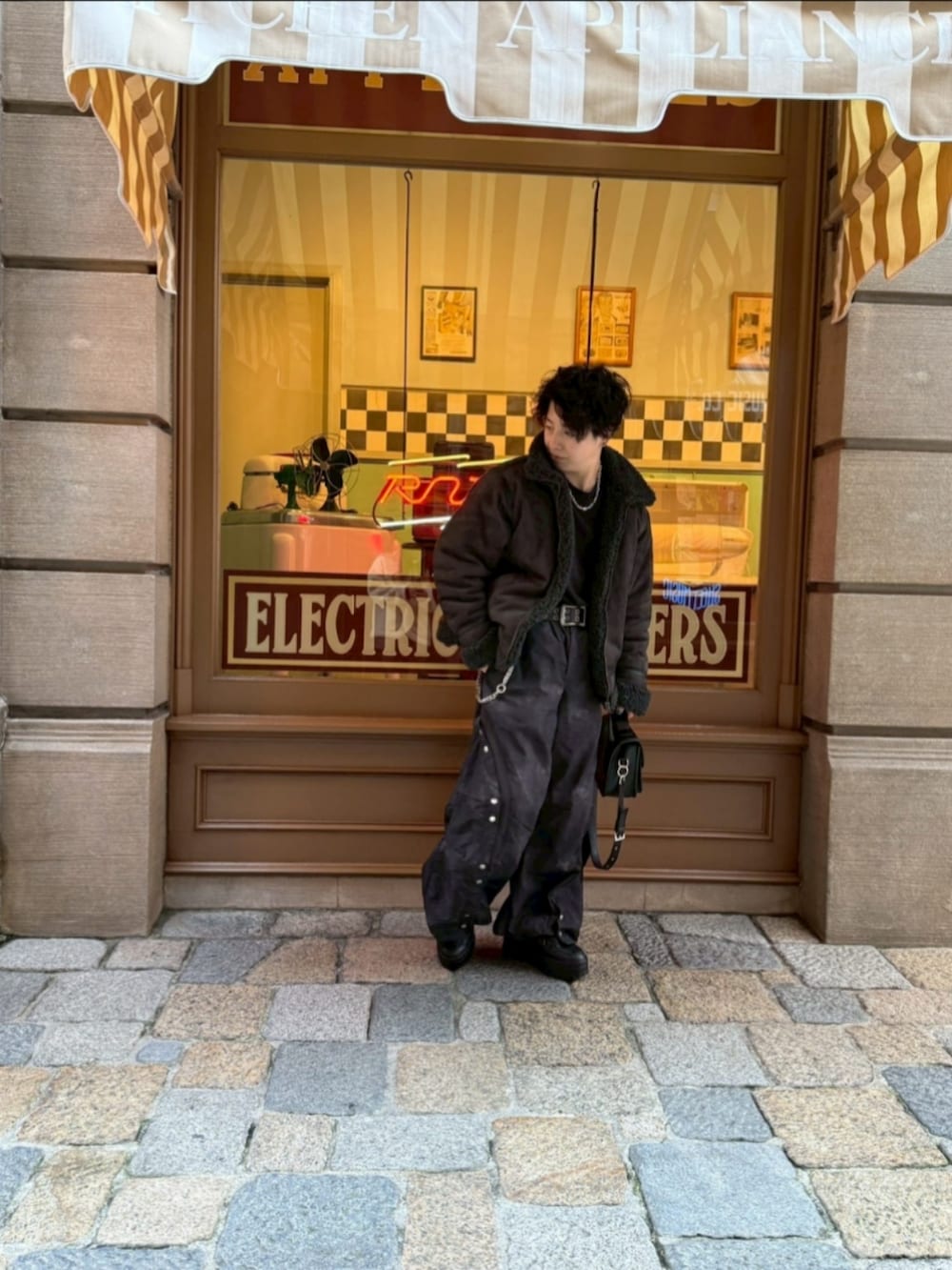 グレー系のムートンコート、ブラック系のスニーカー、ブラック系のその他パンツを着用したメンズの冬コーディネートの3枚目の写真