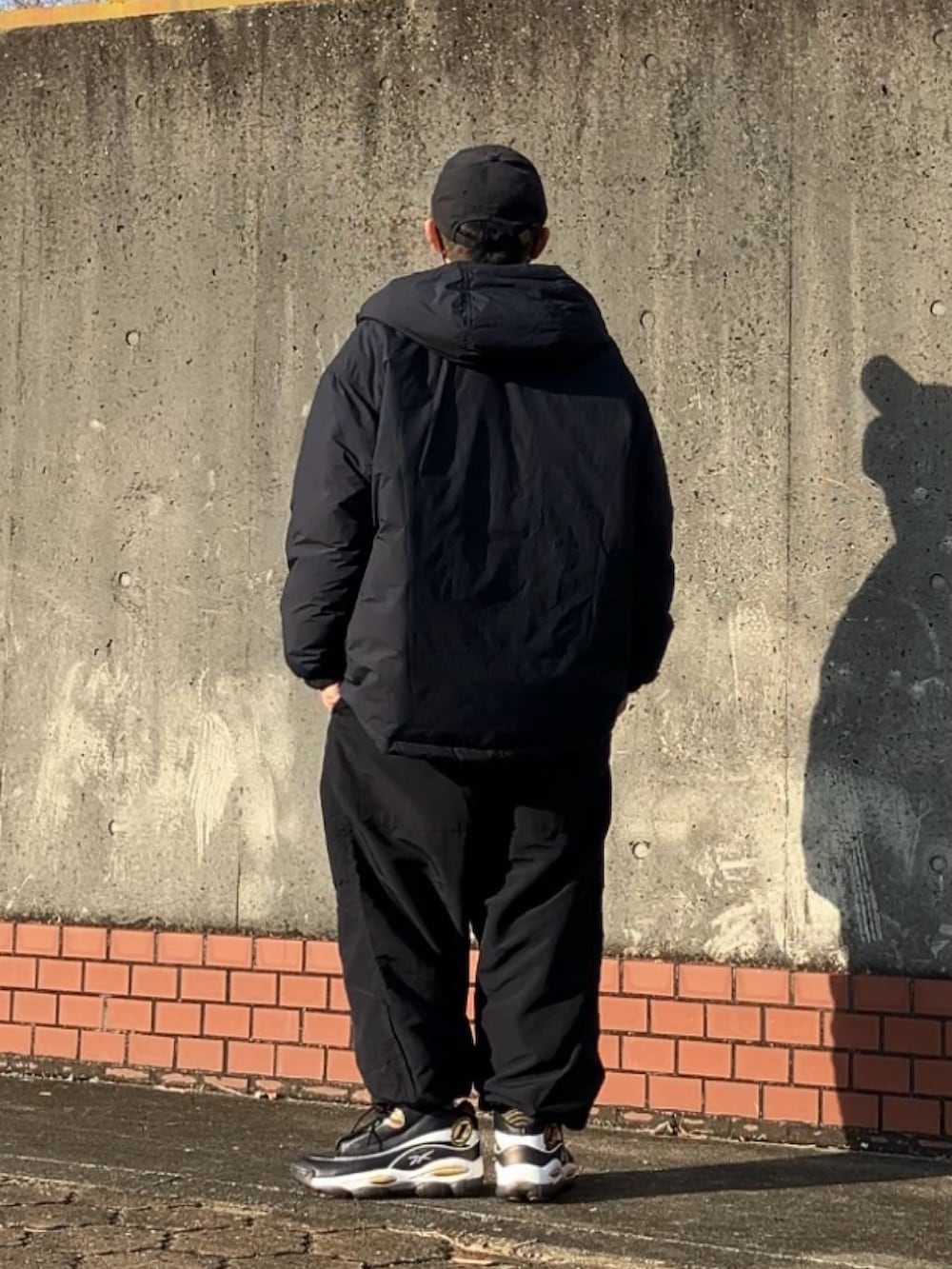 ブラック系のその他パンツ、その他のスウェット、ブラック系のダウンジャケット/コートを着用したメンズの冬コーディネートの2枚目の写真