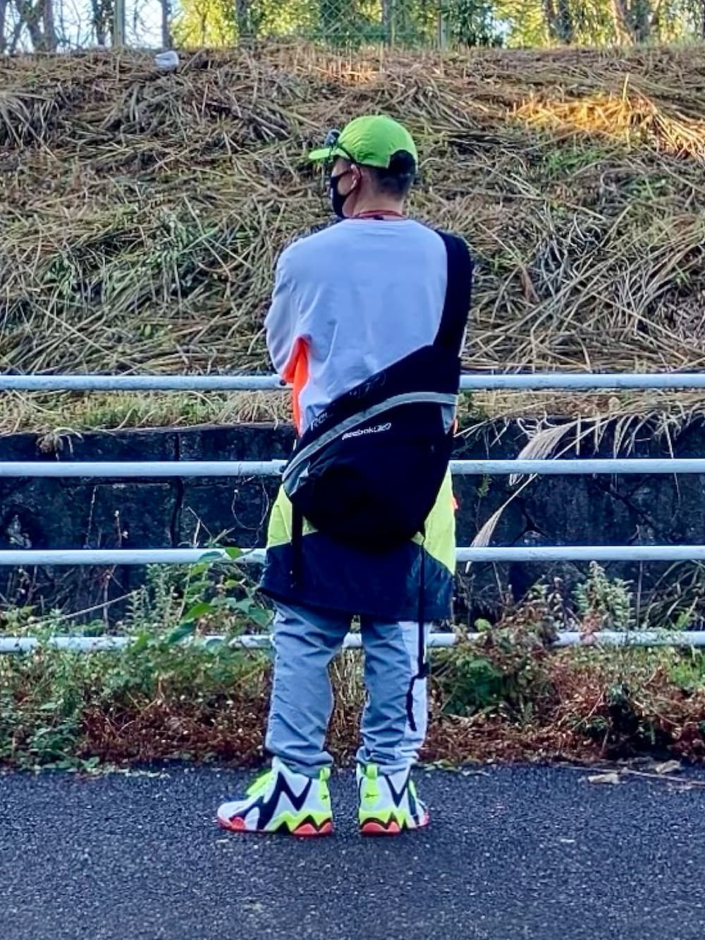 ホワイト系のTシャツ/カットソー、その他のマウンテンパーカー、ブラック系のショルダーバッグを着用したメンズの秋コーディネートの2枚目の写真