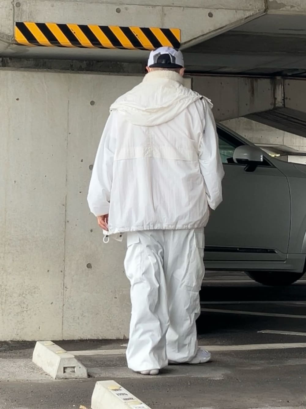 ホワイト系のTシャツ/カットソー、ホワイト系のベスト、ホワイト系のナイロンジャケットを着用したメンズの冬コーディネートの3枚目の写真