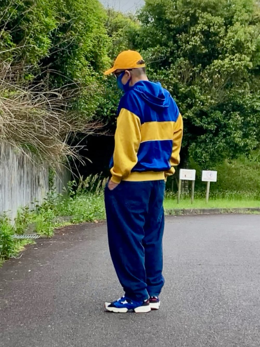 ブルー系のスニーカー、イエロー系のパーカー、イエロー系のキャップを着用したメンズの春コーディネートの2枚目の写真