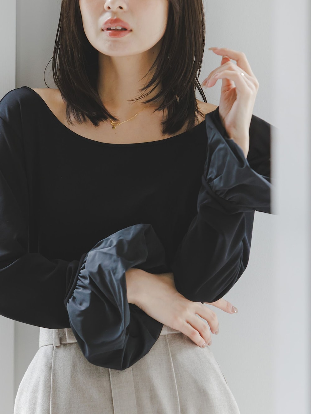 ベージュ系のスラックス、ブラック系のTシャツ/カットソー、ホワイト系のショルダーバッグを着用したレディースの秋コーディネートの6枚目の写真