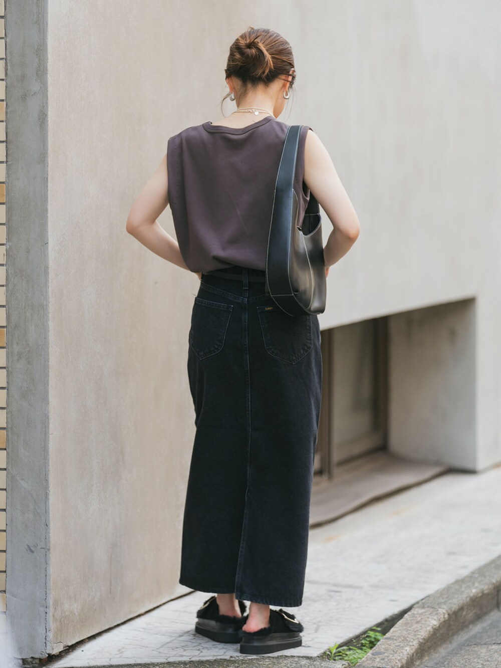 ブラウン系のTシャツ/カットソー、ブラック系のデニムスカート、ブラック系のサンダルを着用したレディースの夏コーディネートの2枚目の写真