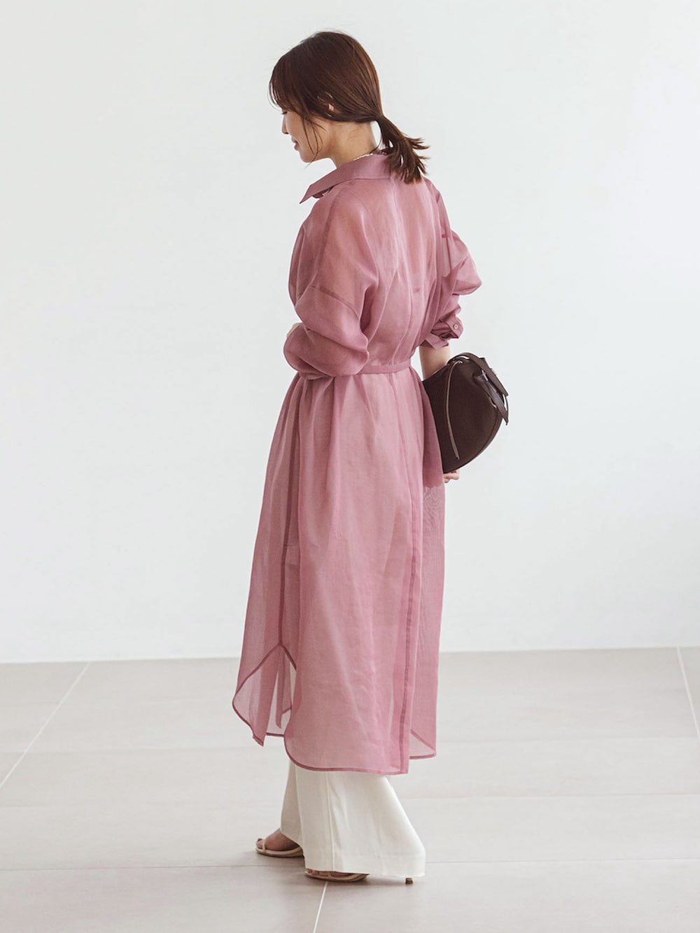 ピンク系のシャツ/ブラウス、ホワイト系のスラックス、レッド系のショルダーバッグを着用したレディースの夏コーディネートの2枚目の写真