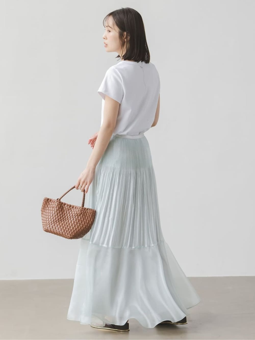 ブルー系のスカート、ホワイト系のTシャツ/カットソー、ホワイト系のTシャツ/カットソーを着用したレディースの春コーディネートの3枚目の写真