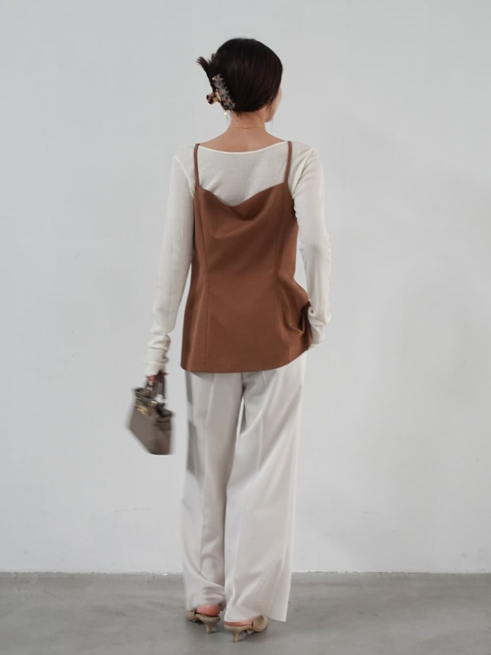 ホワイト系のスラックス、イエロー系のシャツ/ブラウス、ホワイト系のTシャツ/カットソーを着用したレディースの夏コーディネートの3枚目の写真