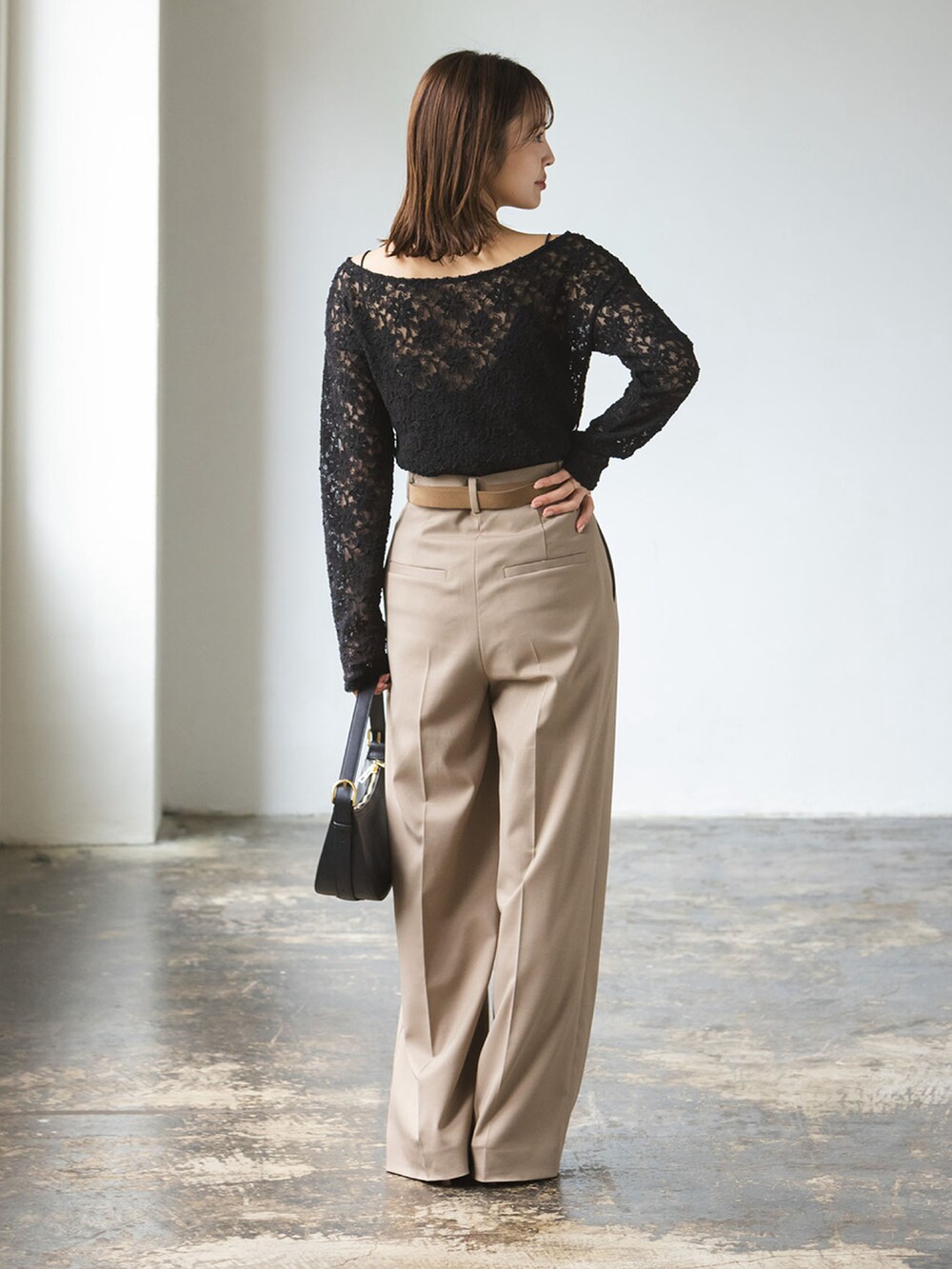 ブラック系のTシャツ/カットソー、ブラウン系のスラックスを着用したレディースの秋コーディネートの2枚目の写真