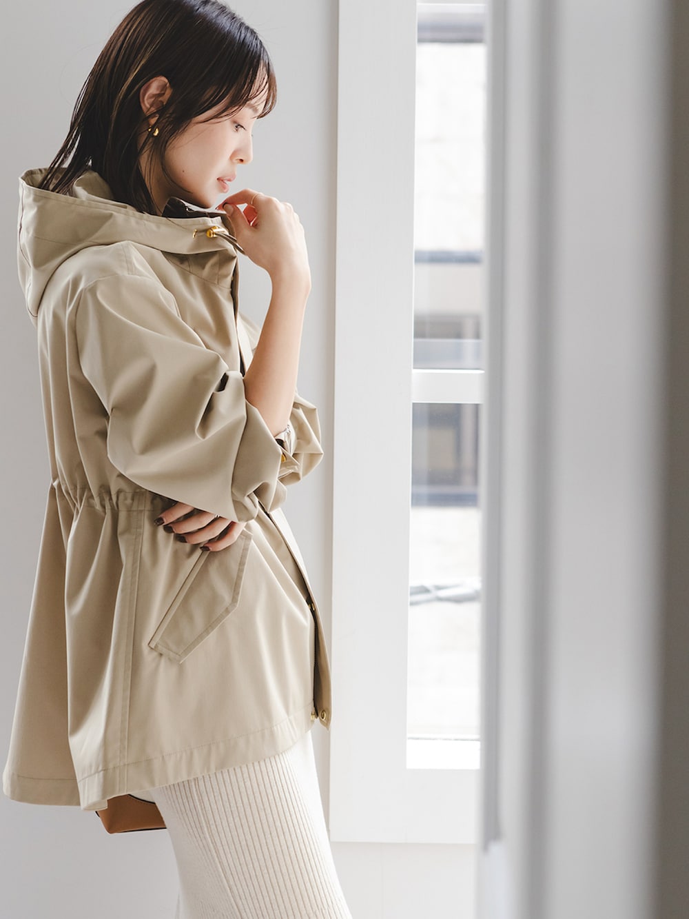 ベージュ系のマウンテンパーカー、ベージュ系のスカート、イエロー系のブーツを着用したレディースの冬コーディネートの2枚目の写真