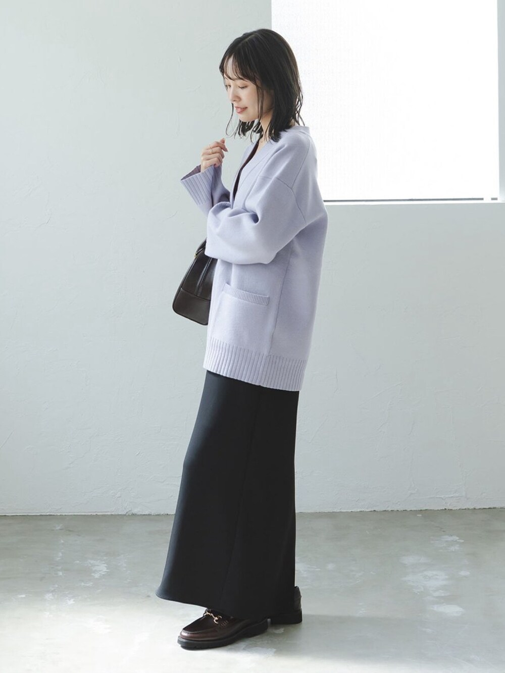 ブルー系のカーディガン/ボレロ、ブラック系のワンピース、ブラウン系のハンドバッグを着用したレディースの秋コーディネートの2枚目の写真