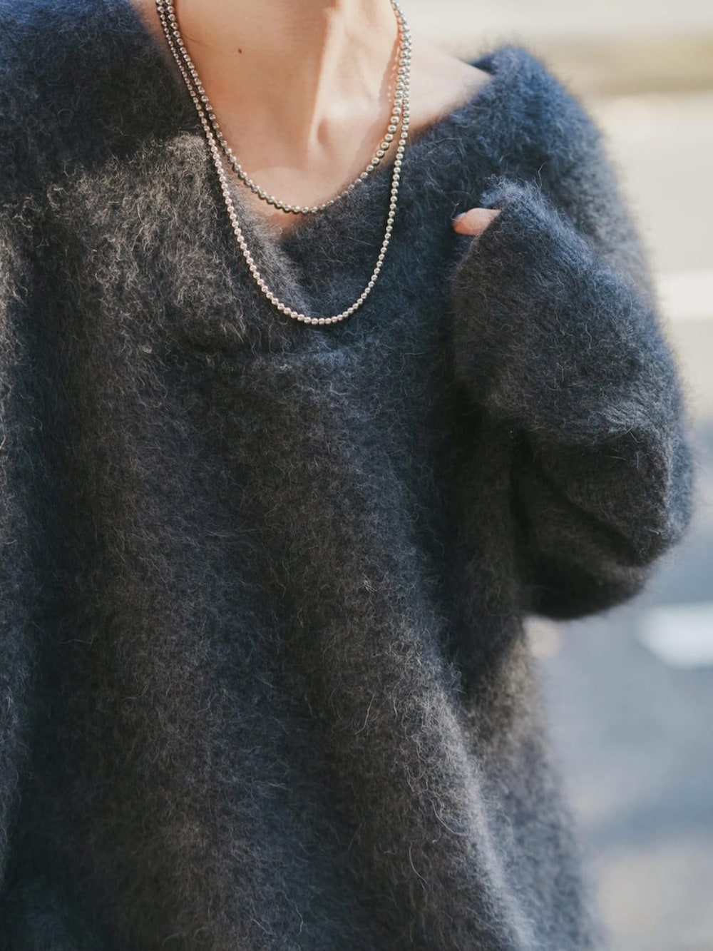 ブラウン系のニット/セーター、ブラック系のブーツ、グレー系のワンピースを着用したレディースの冬コーディネートの3枚目の写真