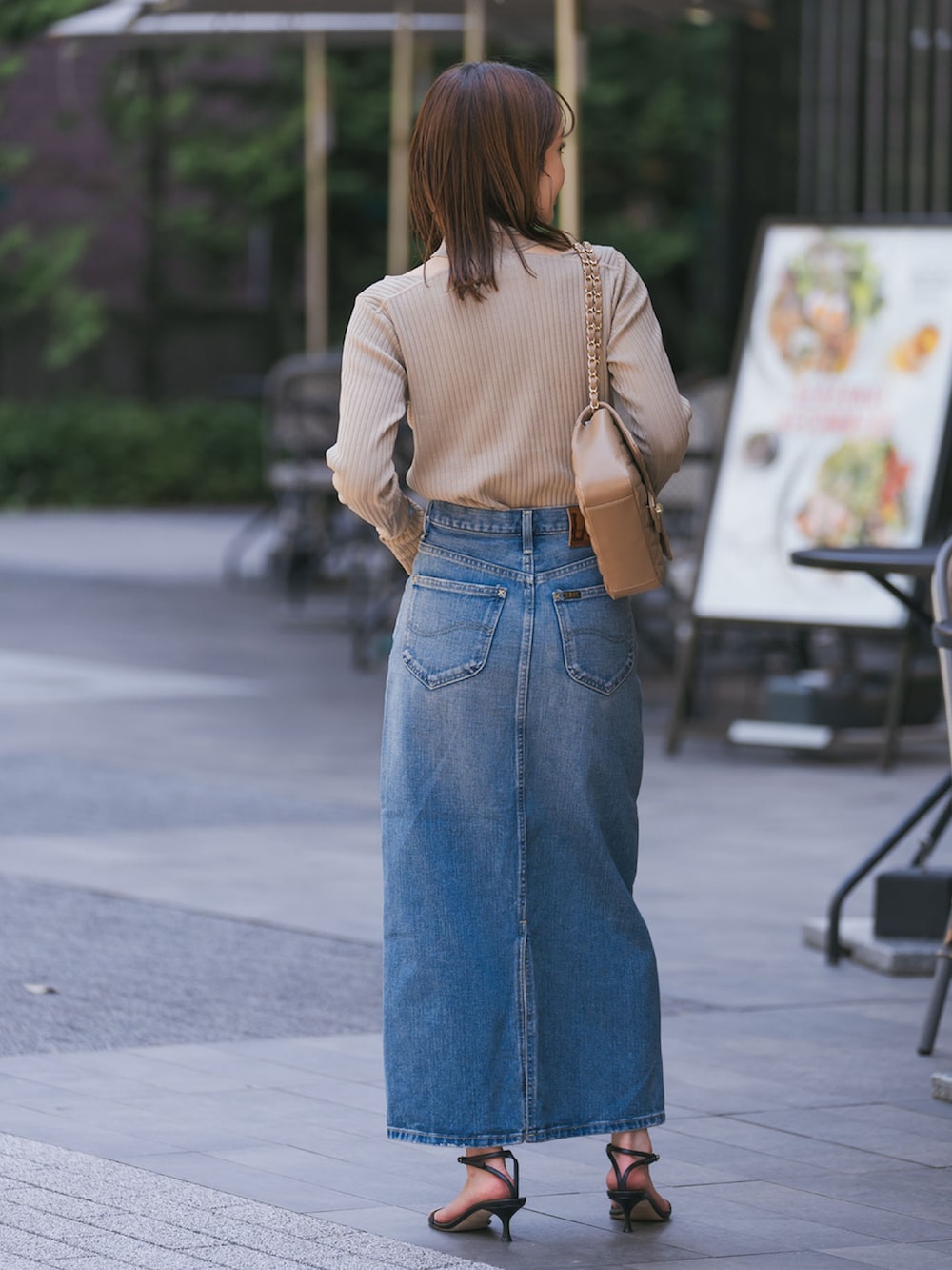 グリーン系のニット/セーター、ブルー系のデニムスカート、ブラック系のサンダルを着用したレディースの夏コーディネートの3枚目の写真