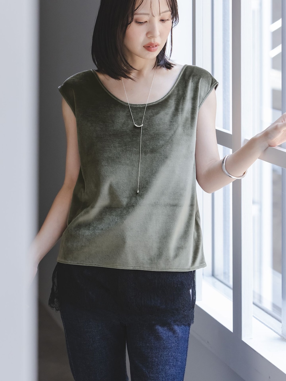 ブルー系のデニムパンツ、ブラック系のキャミソール、グリーン系のTシャツ/カットソーを着用したレディースの夏コーディネートの5枚目の写真