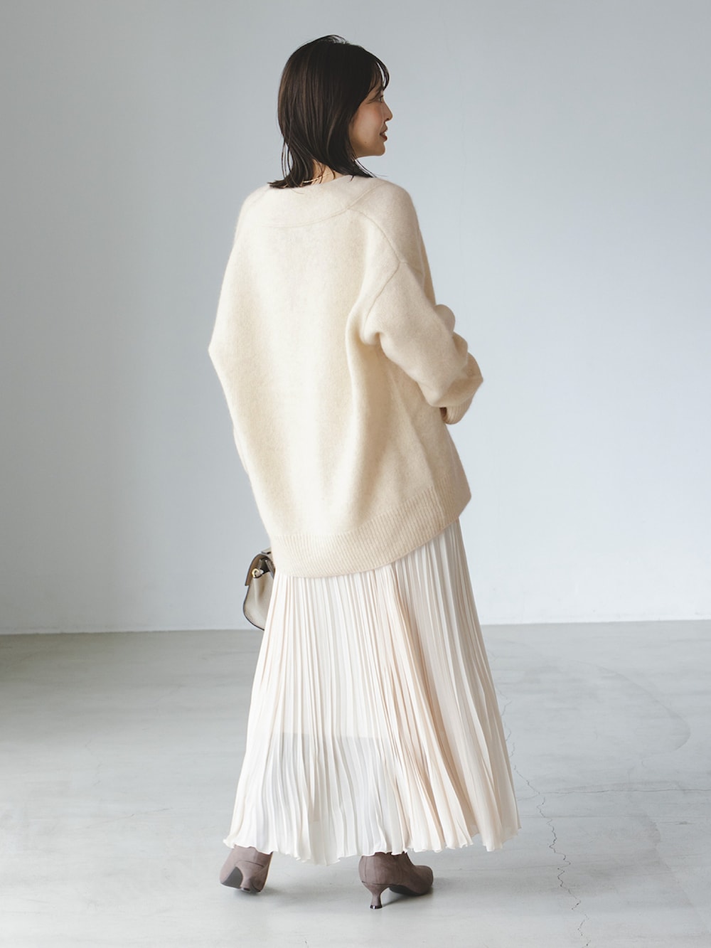 ホワイト系のカーディガン/ボレロ、ホワイト系のワンピース、グレー系のショルダーバッグを着用したレディースの秋コーディネートの2枚目の写真