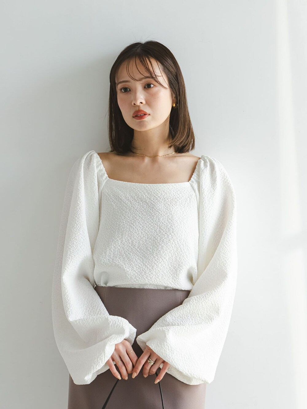 ホワイト系のシャツ/ブラウス、ブラウン系のスカート、ブラック系のショルダーバッグを着用したレディースの春コーディネートの5枚目の写真