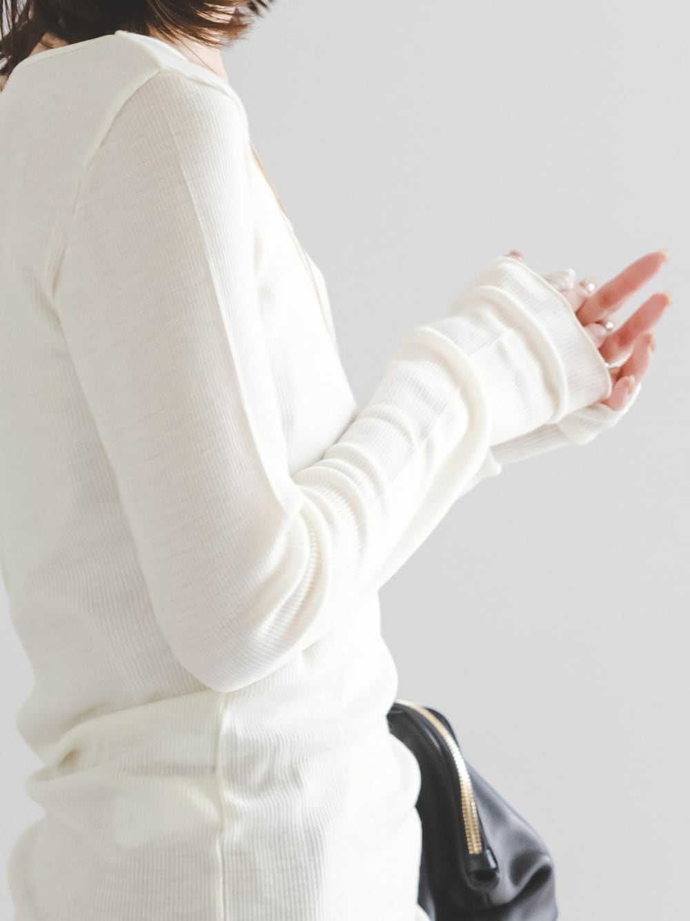 イエロー系のスカート、ホワイト系のTシャツ/カットソー、ブラック系のボストンバッグを着用したレディースの夏コーディネートの6枚目の写真