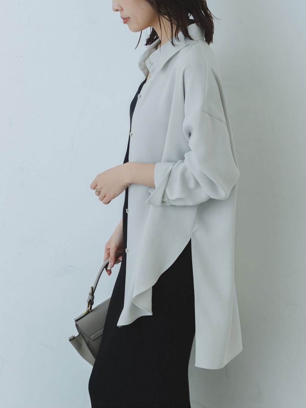 グレー系のシャツ/ブラウス、ブラック系のスカート、グレー系のショルダーバッグを着用したレディースの秋コーディネートの3枚目の写真