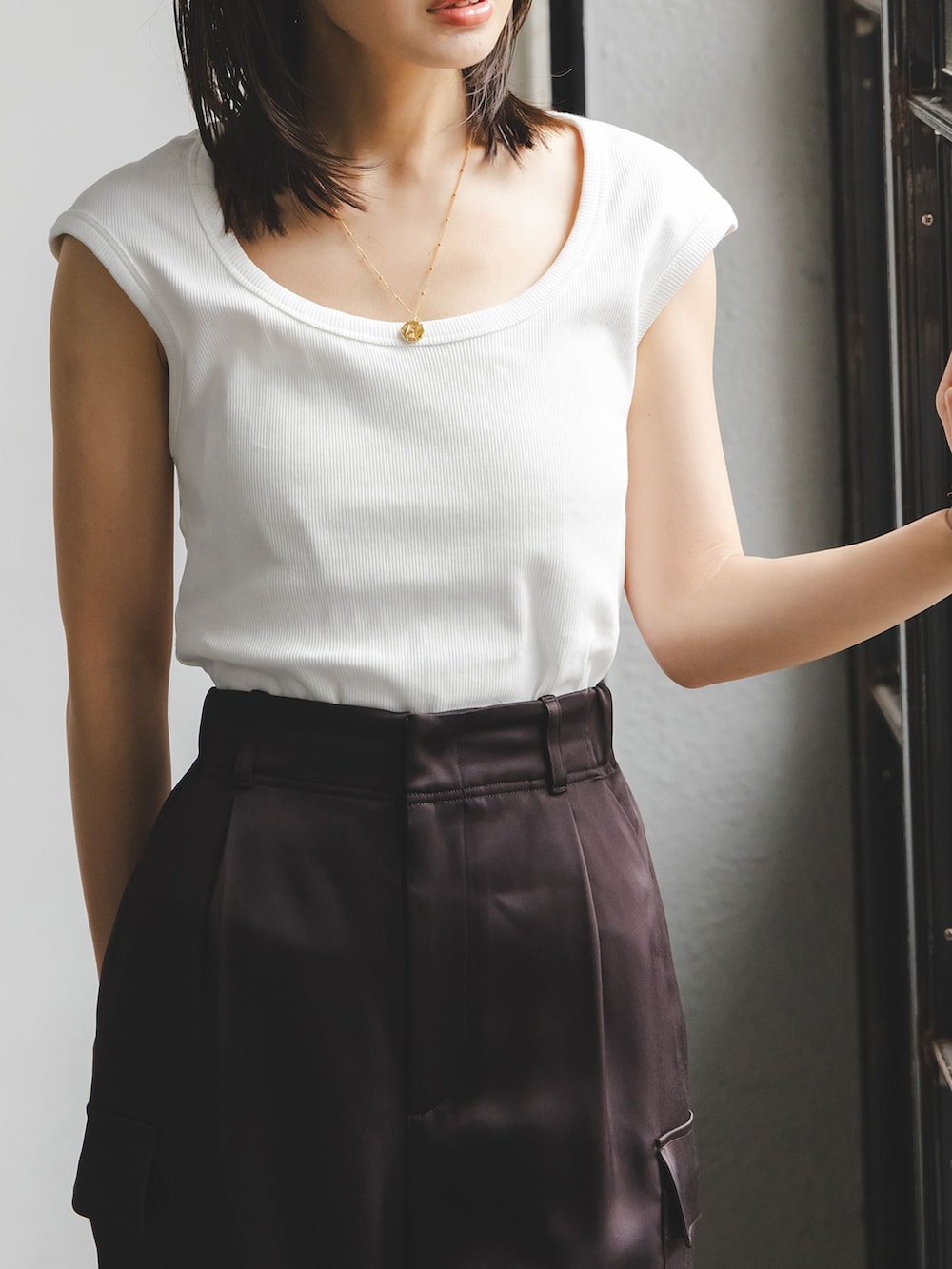 ブラウン系のカーゴパンツ、ホワイト系のTシャツ/カットソー、ベージュ系のショルダーバッグを着用したレディースの夏コーディネートの3枚目の写真