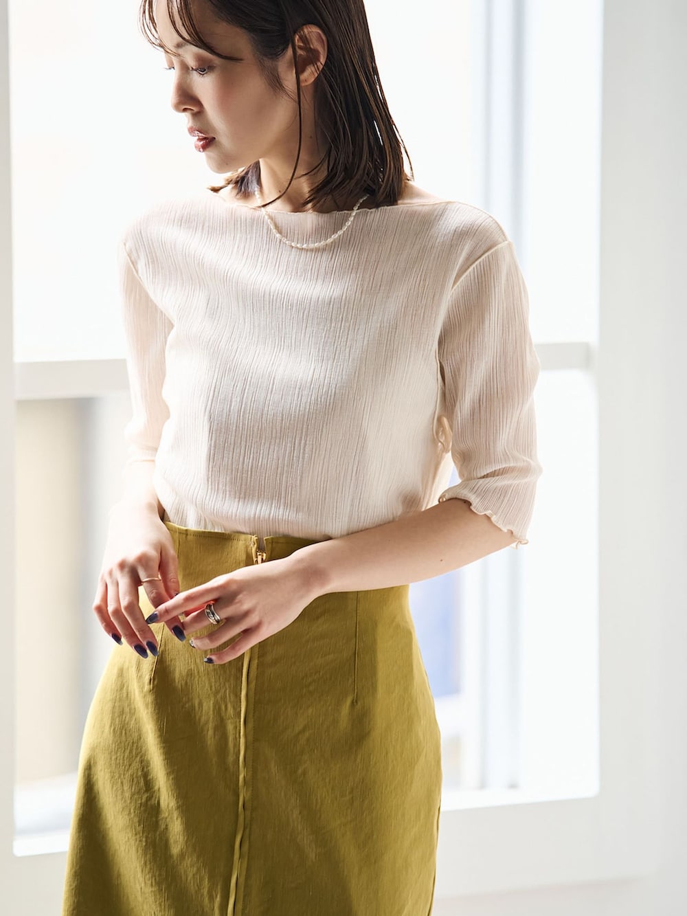 イエロー系のスカート、ホワイト系のTシャツ/カットソー、ブラウン系のショルダーバッグを着用したレディースの春コーディネートの7枚目の写真