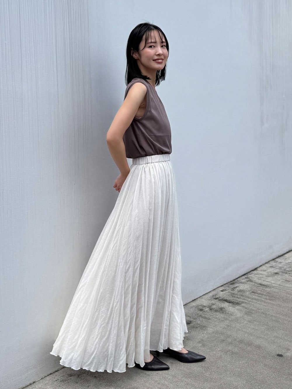 ブラウン系のTシャツ/カットソー、ホワイト系のスカート、ブラウン系のパンプスを着用したレディースの夏コーディネートの2枚目の写真