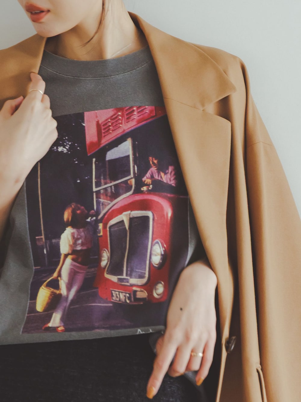 イエロー系のテーラードジャケット、ブラック系のスカート、グレー系のTシャツ/カットソーを着用したレディースの秋コーディネートの9枚目の写真