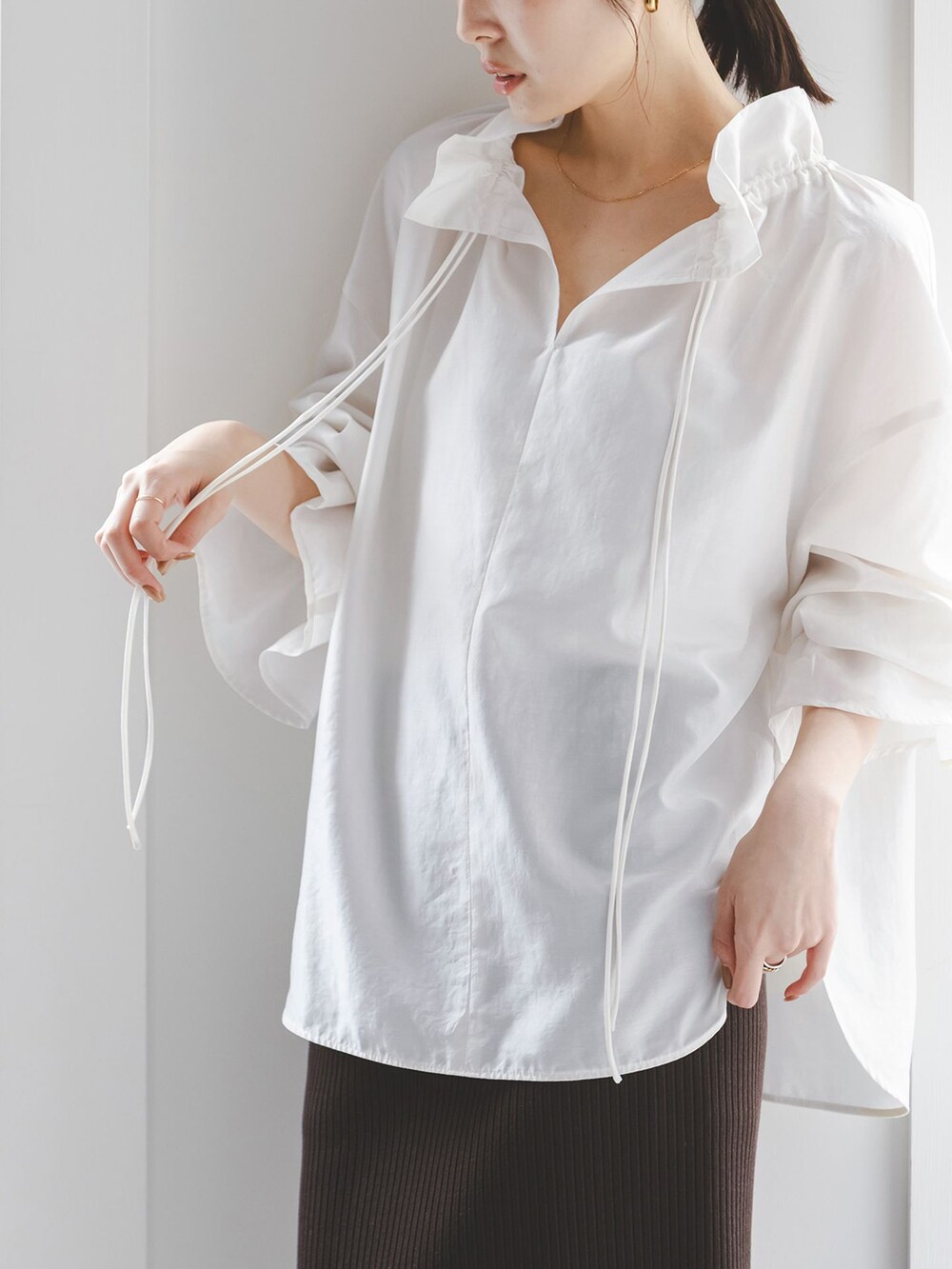 ホワイト系のシャツ/ブラウス、ブラウン系のスカート、ゴールド系のネックレスを着用したレディースの夏コーディネートの4枚目の写真