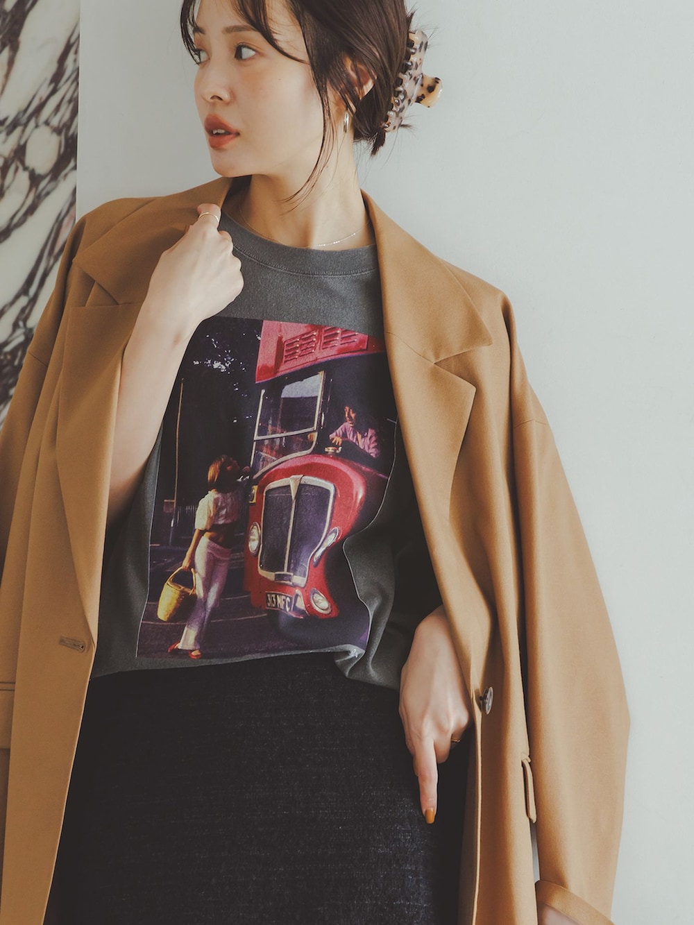 イエロー系のテーラードジャケット、ブラック系のスカート、グレー系のTシャツ/カットソーを着用したレディースの秋コーディネートの10枚目の写真