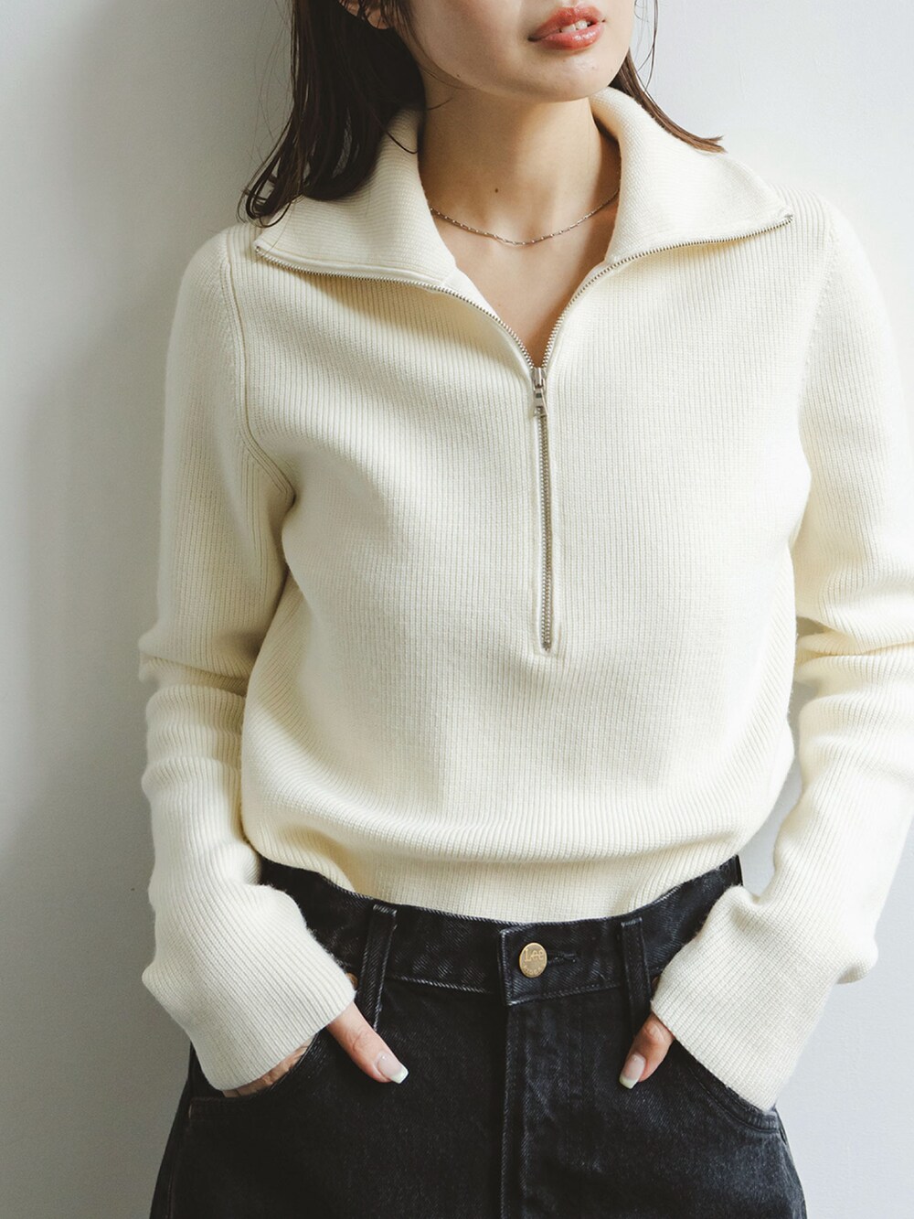 ホワイト系のニット/セーター、ブラック系のデニムスカート、イエロー系のショルダーバッグを着用したレディースの秋コーディネートの3枚目の写真