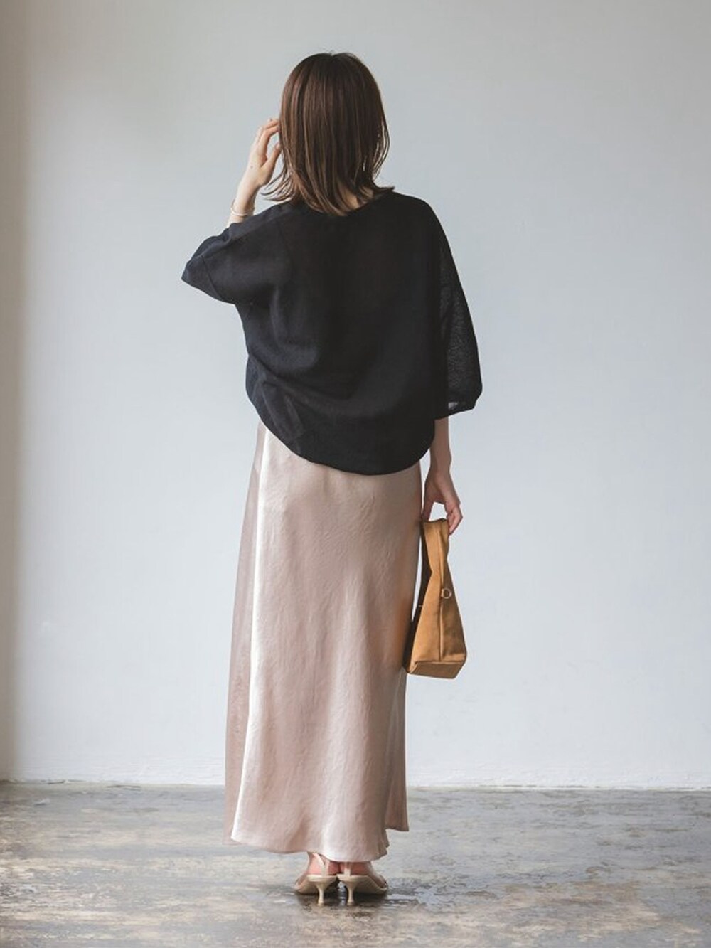 ブラック系のニット/セーター、ベージュ系のサンダルを着用したレディースの夏コーディネートの2枚目の写真