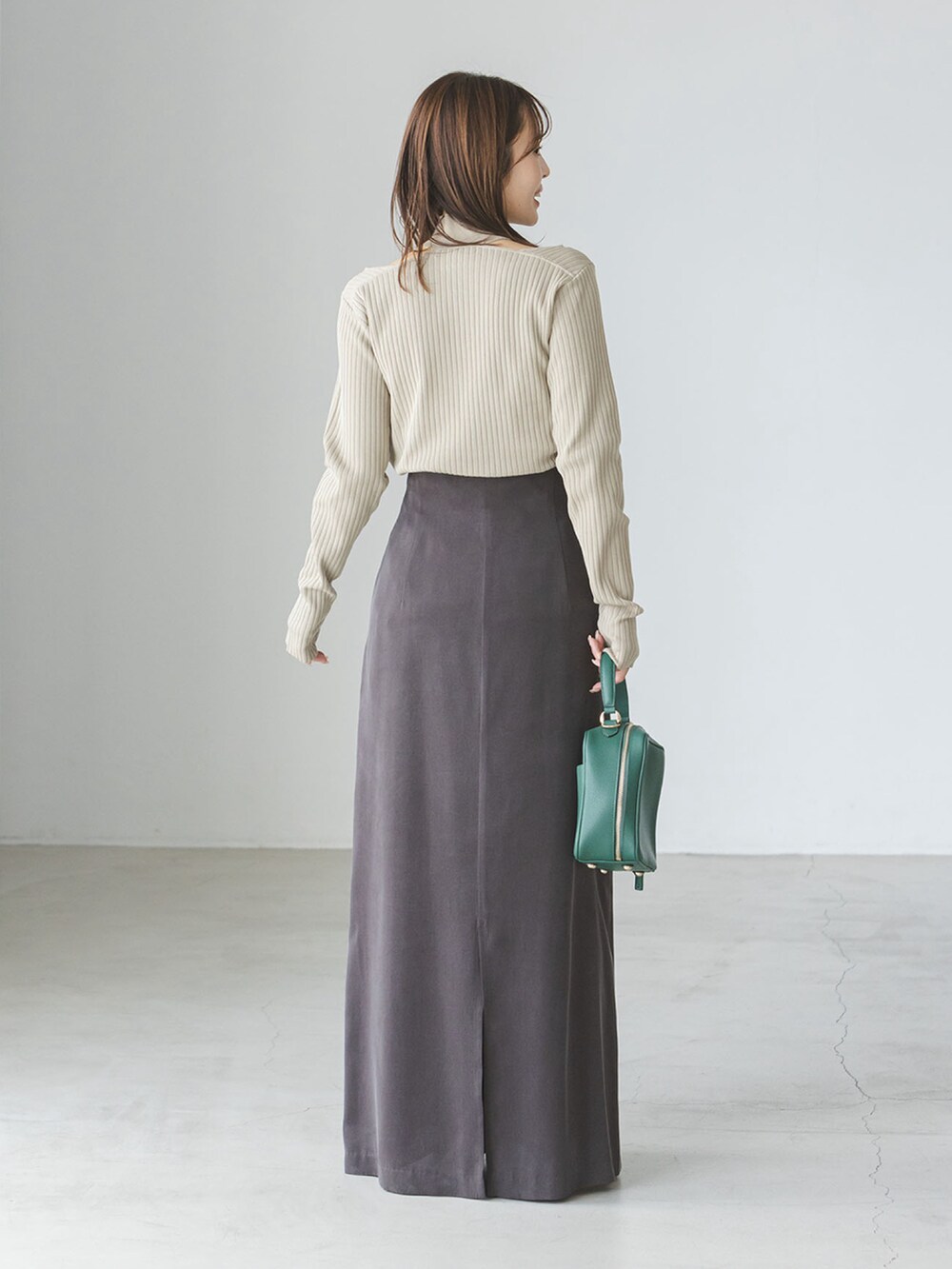 グリーン系のニット/セーター、グリーン系のショルダーバッグ、ブラック系のサンダルを着用したレディースの夏コーディネートの2枚目の写真