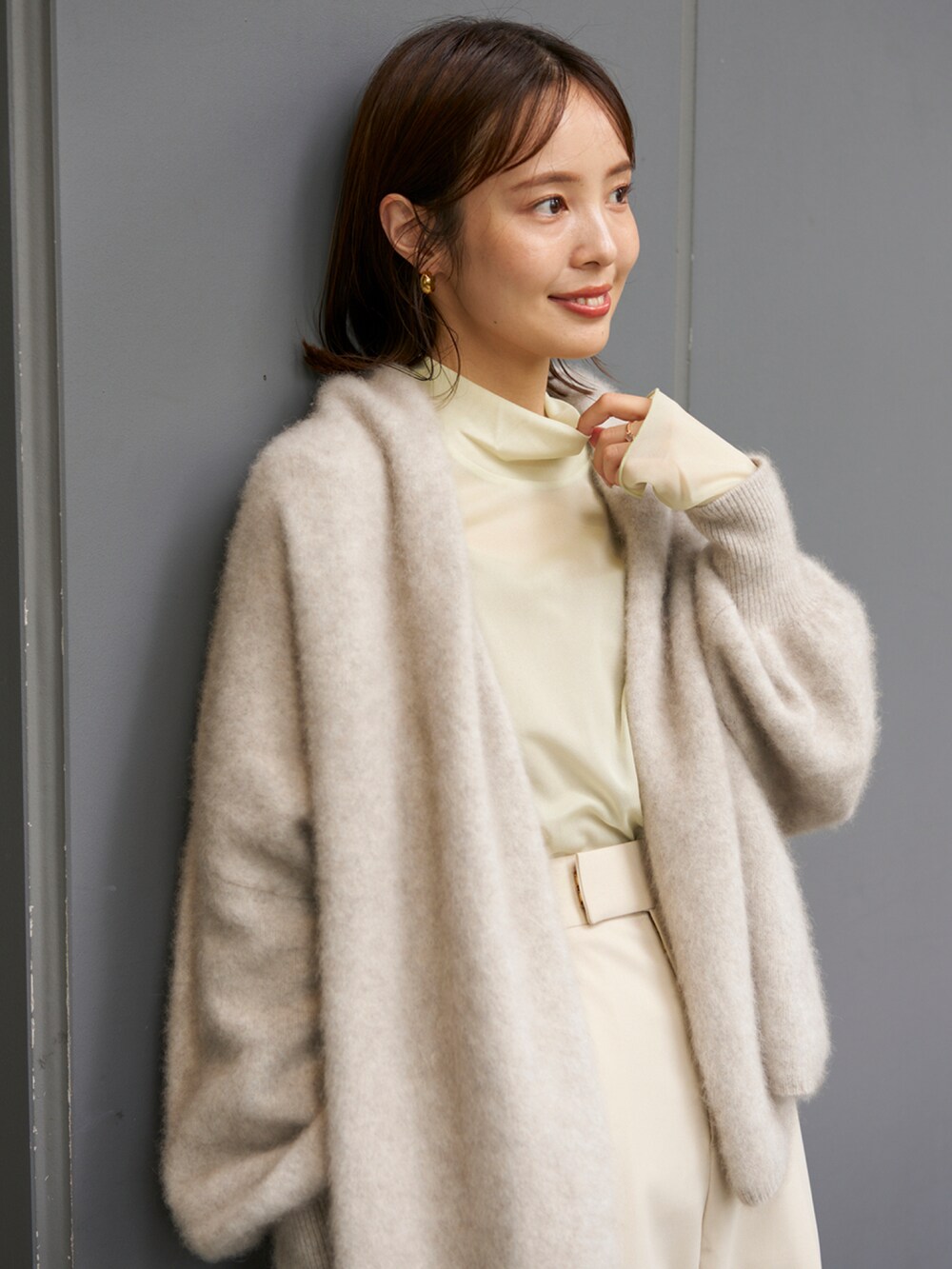 グレー系のカーディガン/ボレロ、グリーン系のTシャツ/カットソー、ベージュ系のスラックスを着用したレディースの秋コーディネートの3枚目の写真