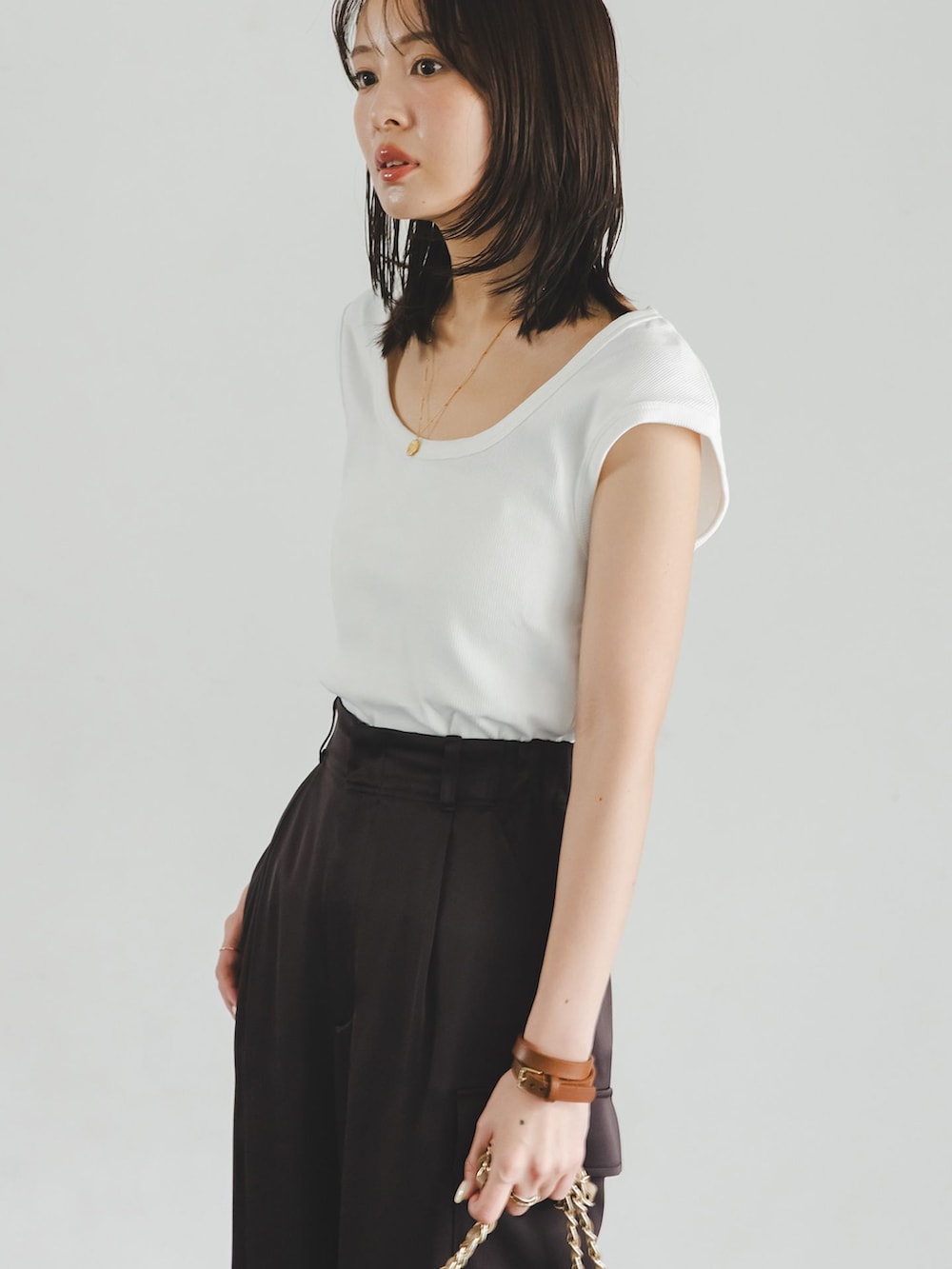 ブラウン系のカーゴパンツ、ホワイト系のTシャツ/カットソー、ベージュ系のショルダーバッグを着用したレディースの夏コーディネートの5枚目の写真