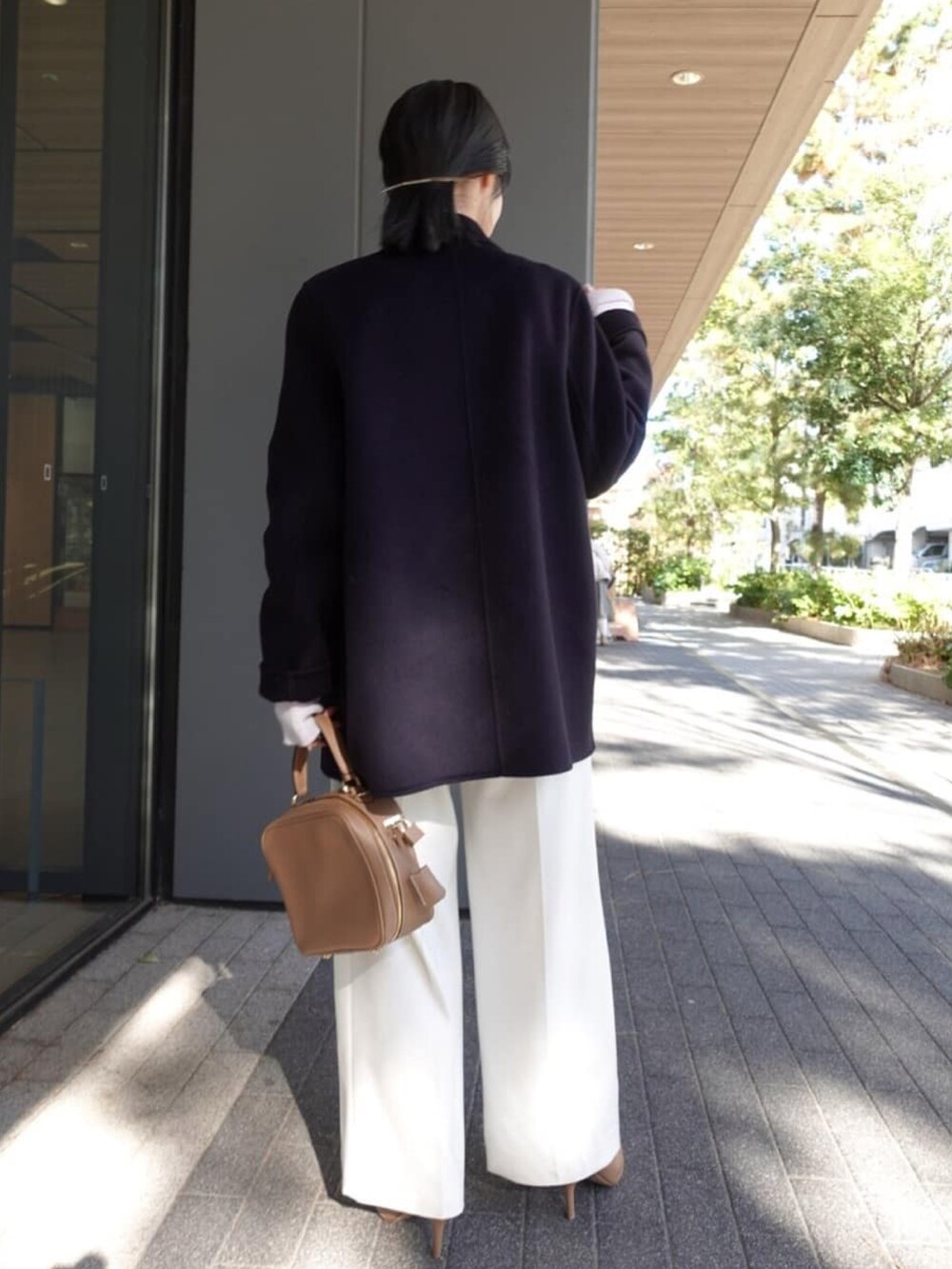 ブルー系のチェスターコート、ホワイト系のスラックス、ベージュ系のブーツを着用したレディースの冬コーディネートの2枚目の写真