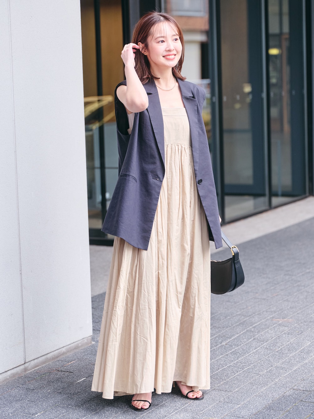 ブラック系のハンドバッグ、その他のジャケット/アウター、ベージュ系のワンピースを着用したレディースの春コーディネートの2枚目の写真