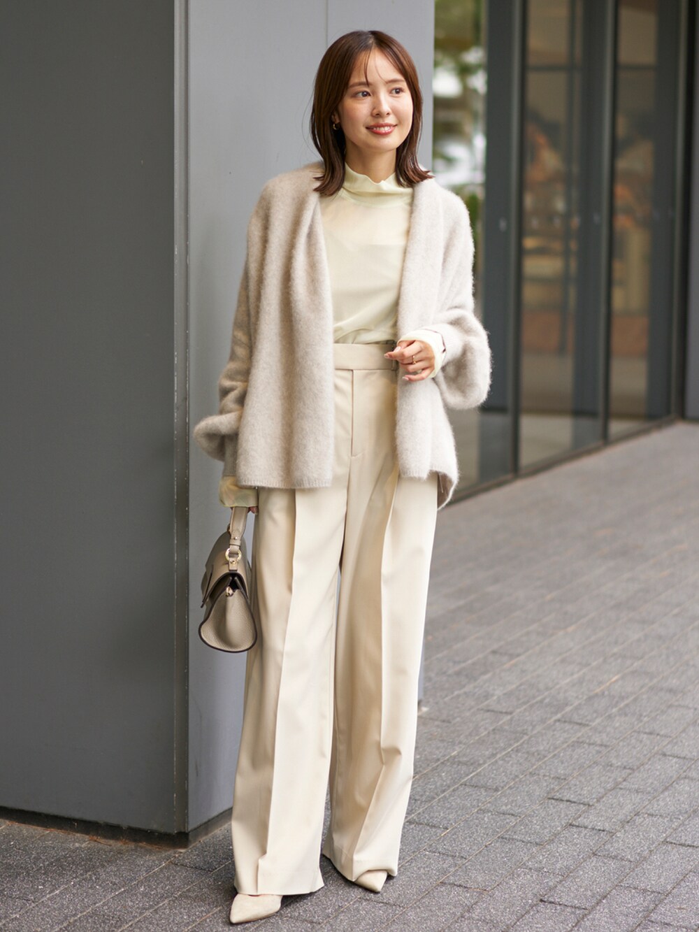 グレー系のカーディガン/ボレロ、グリーン系のTシャツ/カットソー、ベージュ系のスラックスを着用したレディースの秋コーディネートの2枚目の写真