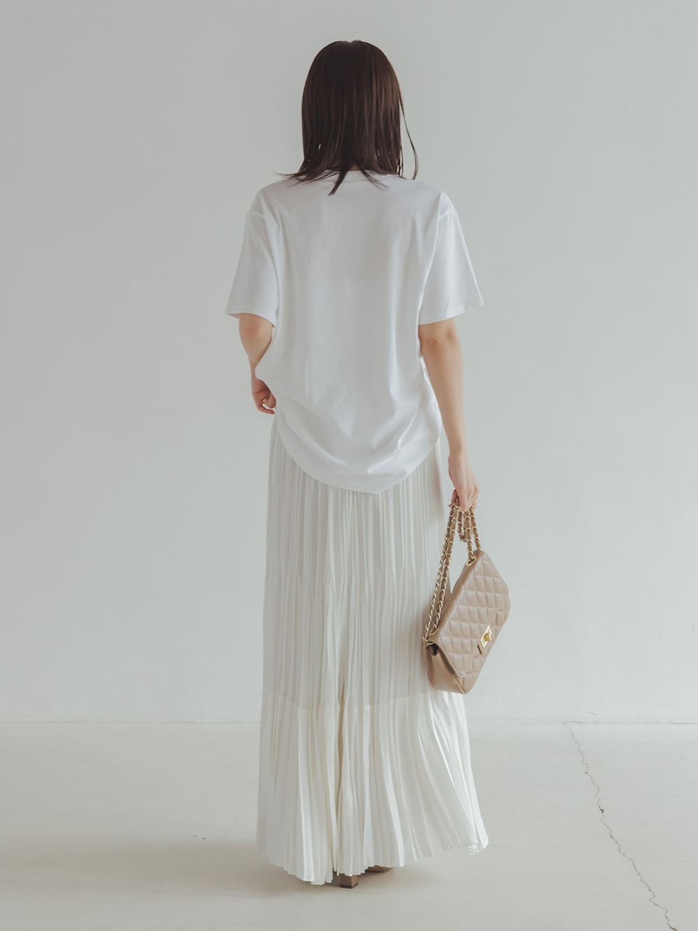 ブラック系のその他アウター、ホワイト系のスカート、ホワイト系のTシャツ/カットソーを着用したレディースの秋コーディネートの3枚目の写真