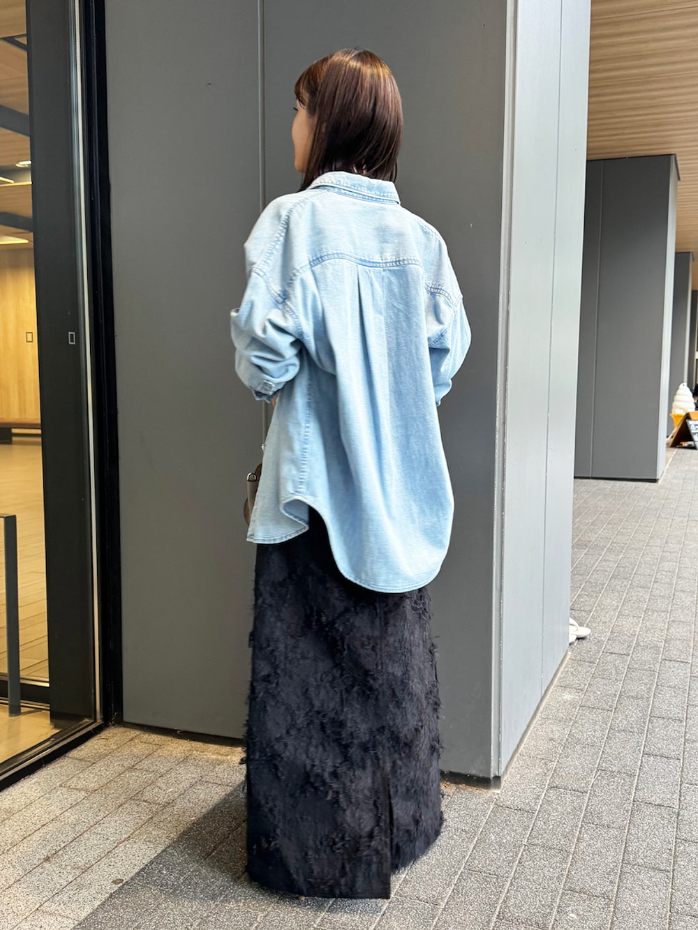 ブルー系のシャツ/ブラウス、ブラック系のスカート、グレー系のショルダーバッグを着用したレディースの秋コーディネートの2枚目の写真