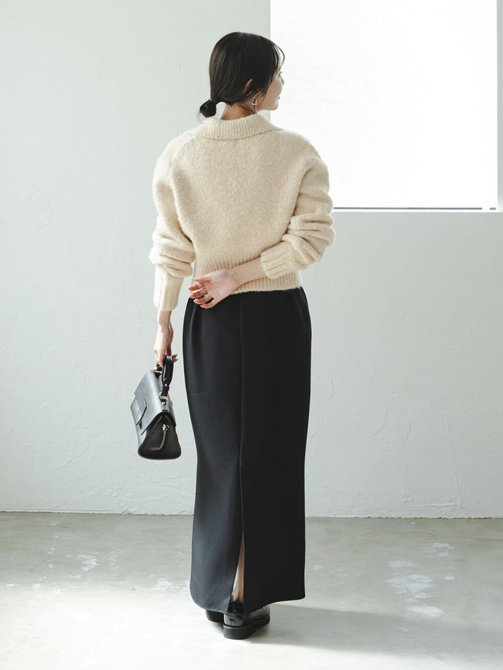 ベージュ系のカーディガン/ボレロ、ブラック系のワンピース、ブラック系のショルダーバッグを着用したレディースの秋コーディネートの3枚目の写真