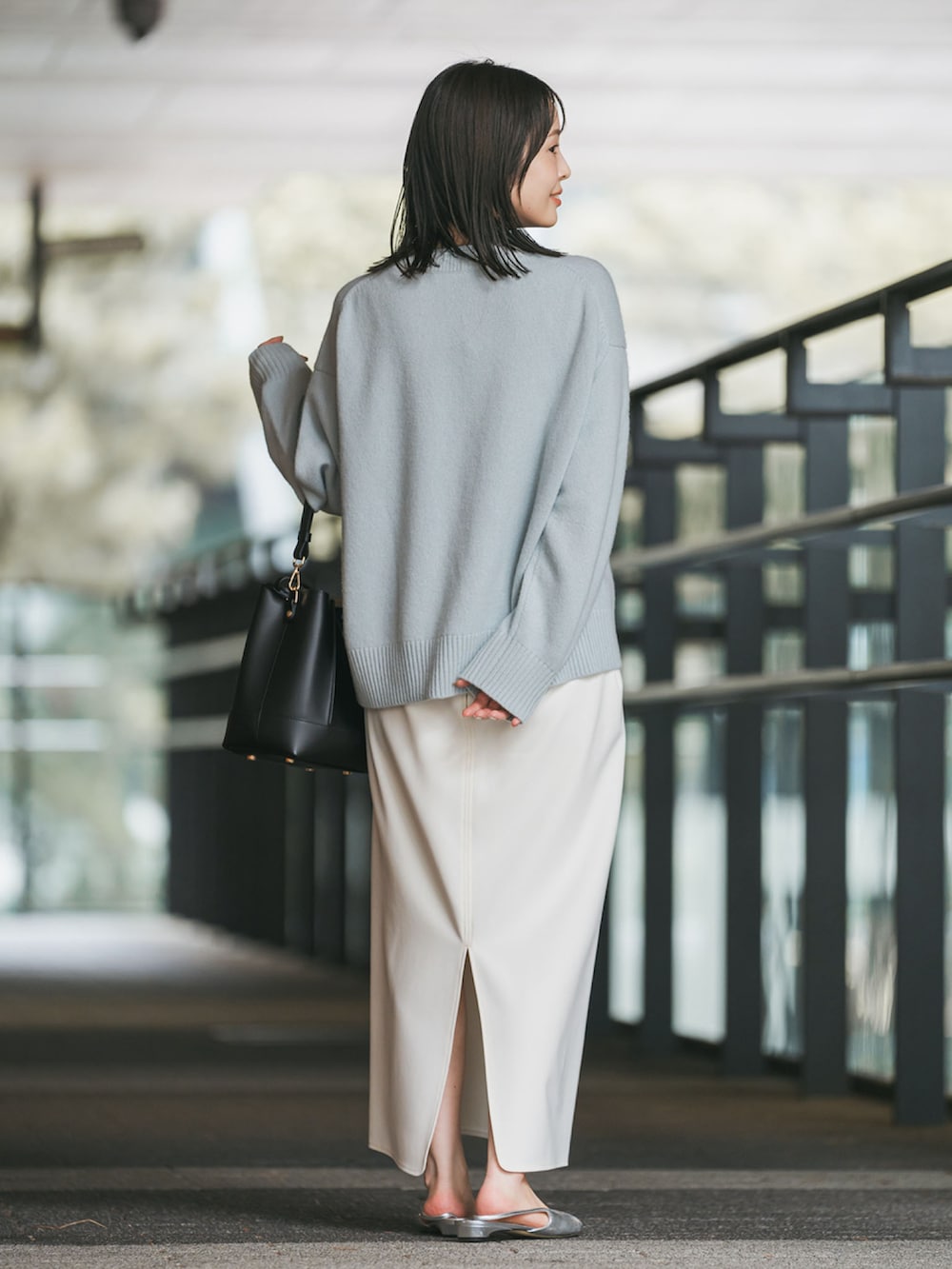 ブルー系のニット/セーター、ホワイト系のスカート、シルバー系のパンプスを着用したレディースの秋コーディネートの2枚目の写真