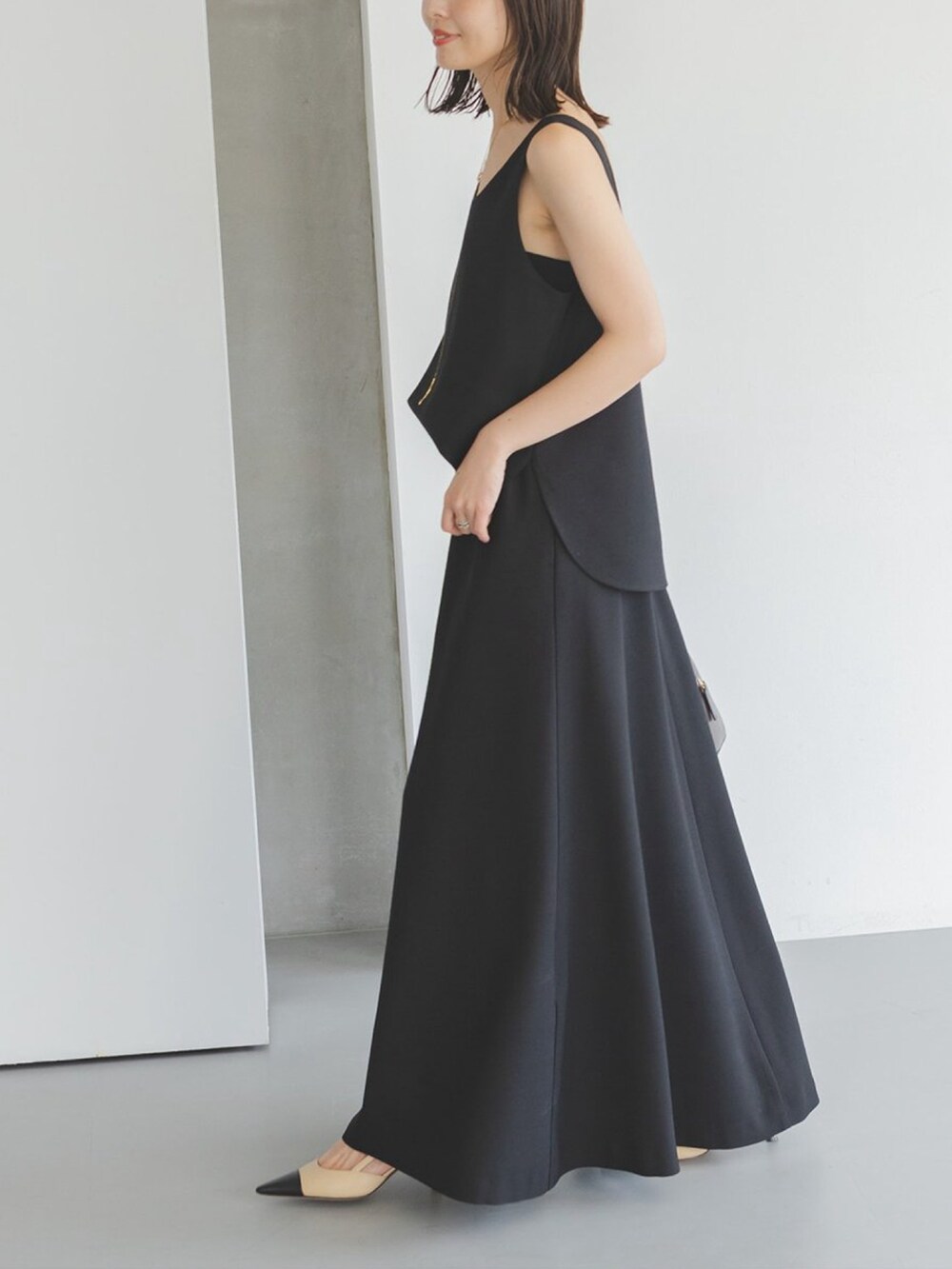 ブラック系のワンピース、ブラウン系のハンドバッグを着用したレディースの夏コーディネートの3枚目の写真