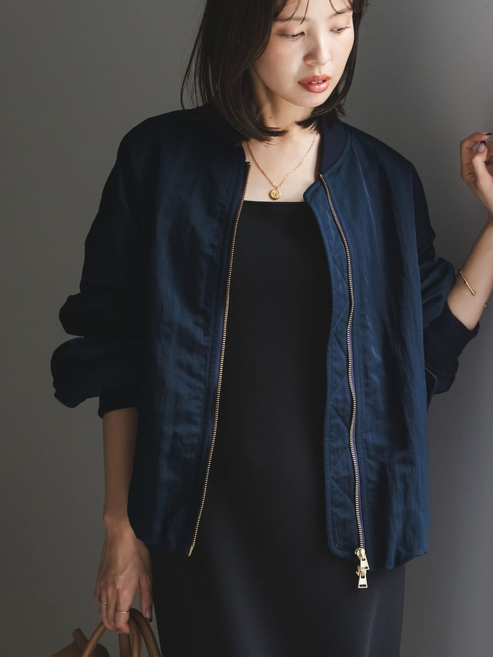 ブルー系のMA-1、グリーン系のワンピース、イエロー系のボストンバッグを着用したレディースの秋コーディネートの4枚目の写真