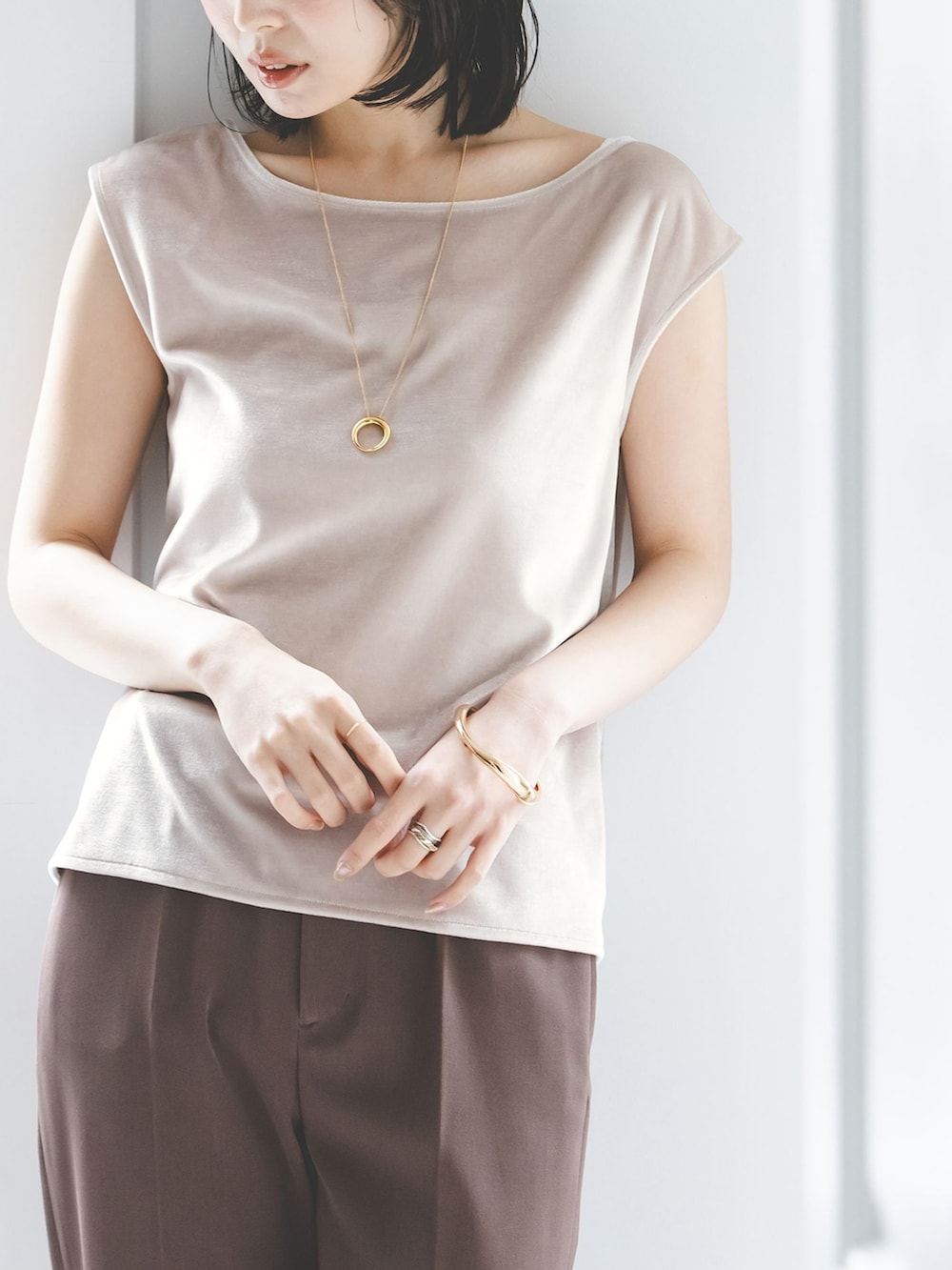 ブラウン系のスラックス、ベージュ系のTシャツ/カットソー、ホワイト系のボストンバッグを着用したレディースの夏コーディネートの7枚目の写真