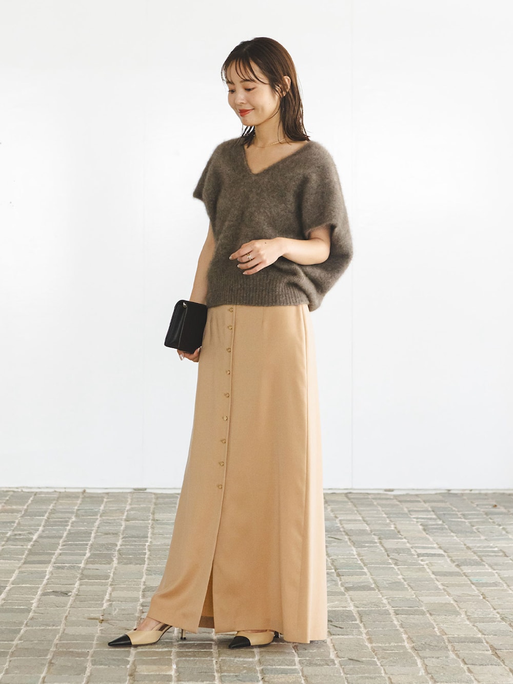 ブラウン系のベスト、ベージュ系のスカートを着用したレディースの夏コーディネートの2枚目の写真