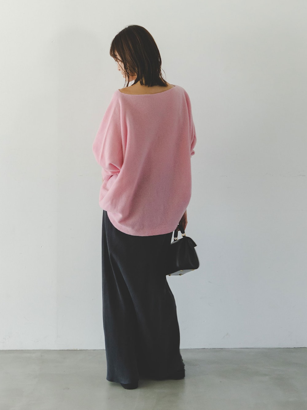 ピンク系のニット/セーター、ブルー系のスカートを着用したレディースの秋コーディネートの2枚目の写真