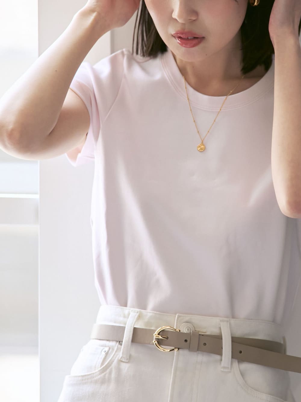 ホワイト系のデニムスカート、ピンク系のTシャツ/カットソー、ベージュ系のパンプスを着用したレディースの春コーディネートの5枚目の写真