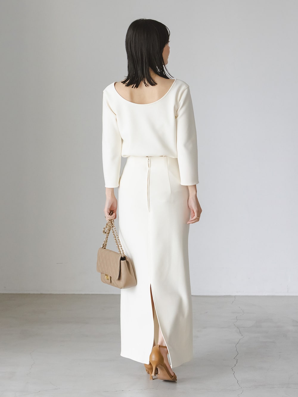 ホワイト系のシャツ/ブラウス、ホワイト系のスカート、ベージュ系のショルダーバッグを着用したレディースの冬コーディネートの2枚目の写真