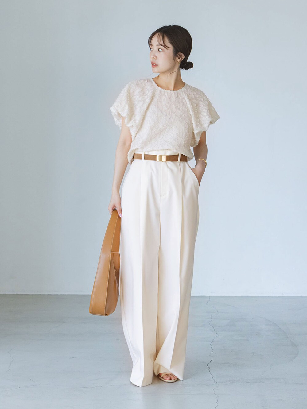 ベージュ系のシャツ/ブラウス、ベージュ系のスラックスを着用したレディースの夏コーディネートの2枚目の写真