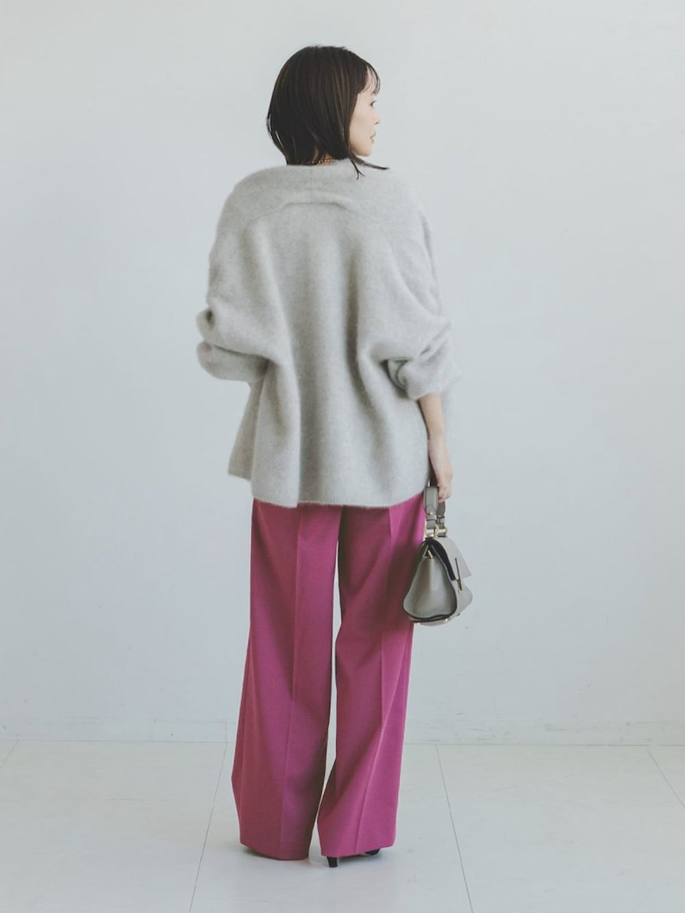 グレー系のタンクトップ、グレー系のカーディガン/ボレロ、ピンク系のスラックスを着用したレディースの秋コーディネートの2枚目の写真