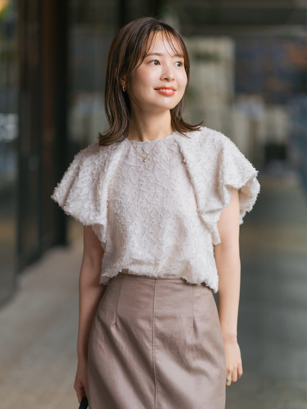 ブラウン系のスカート、ベージュ系のシャツ/ブラウスを着用したレディースの夏コーディネートの3枚目の写真