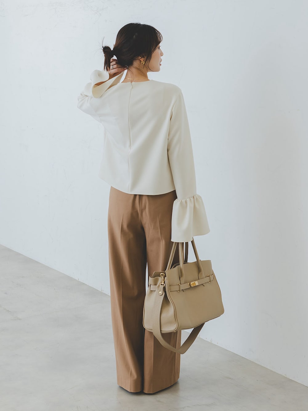 ホワイト系のシャツ/ブラウス、ベージュ系のパンプス、ベージュ系のショルダーバッグを着用したレディースの秋コーディネートの3枚目の写真