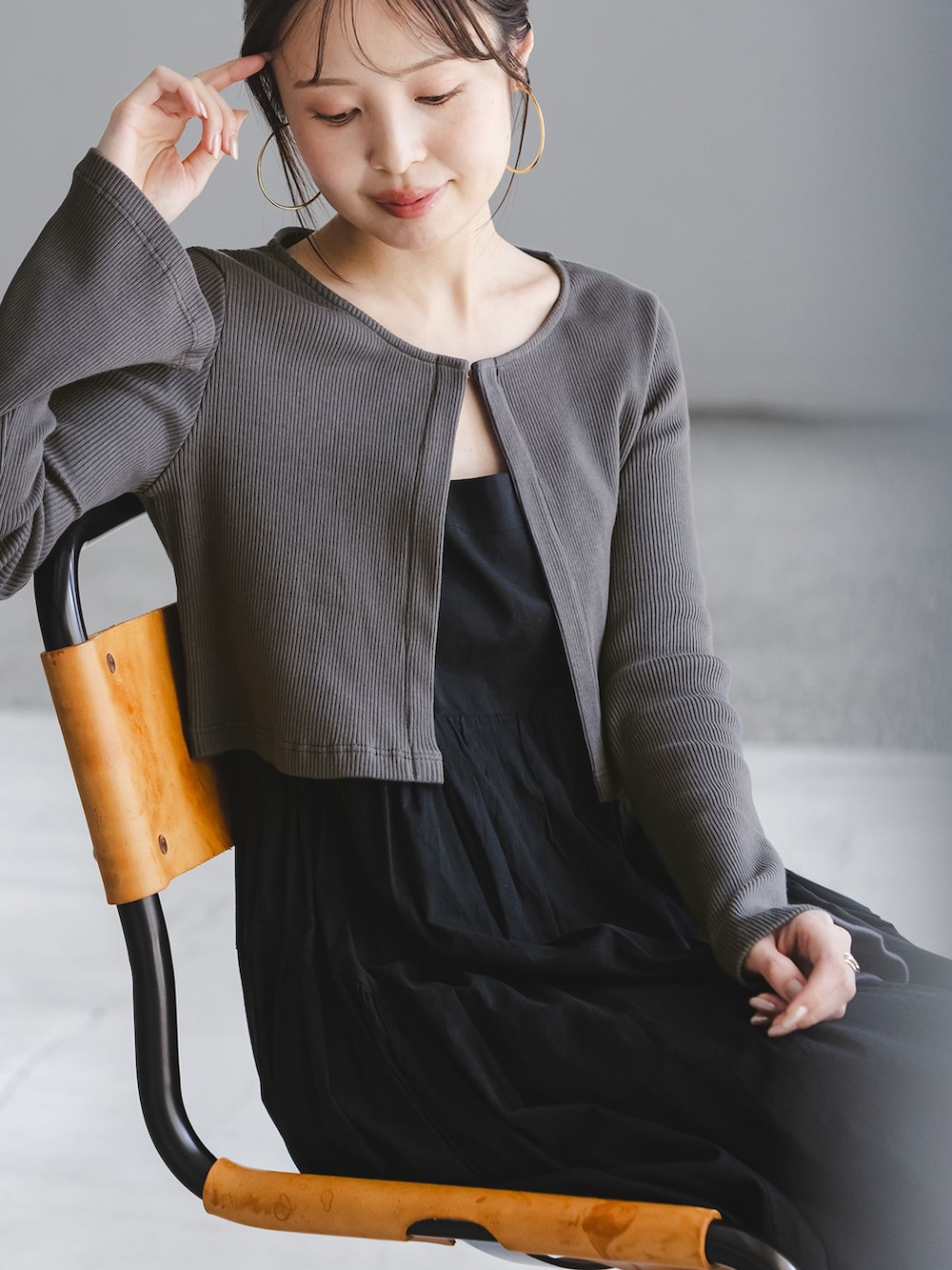ブラック系のワンピース、グレー系のカーディガン/ボレロ、ホワイト系のハンドバッグを着用したレディースの春コーディネートの7枚目の写真